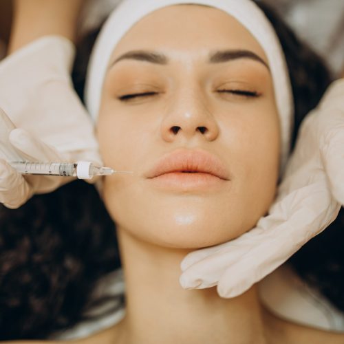 Woman making injections at cosmetologist